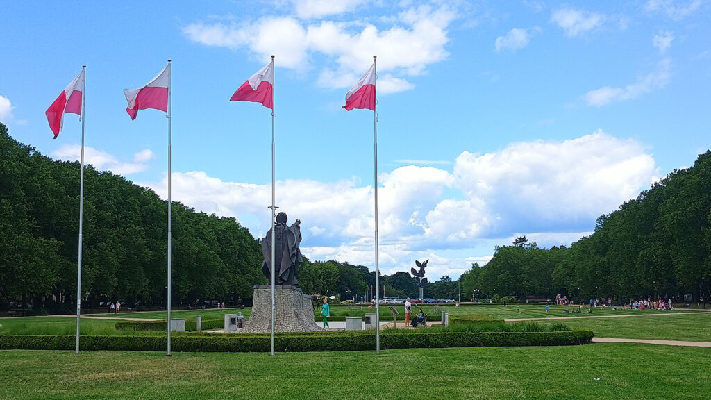Blick von der Rathaus-Seite (wo sich die Ausstellung befindet) auf Jasne Błonia mit Papst-Denkmal und dem Denkmal mit den drei Adlern.
Foto: © Brygida Helbig, 2025